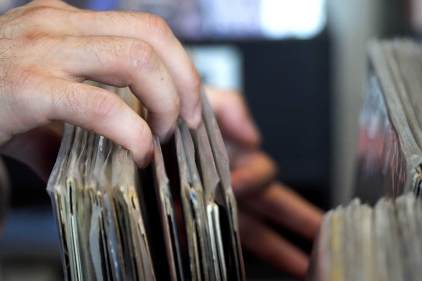 A customer browses vinyl records at a music store