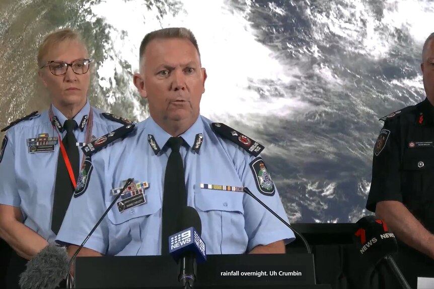 A screenshot of a police press conference shows a closed caption for Currumbin spelt as 'Uh Crumbin'.