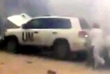 A man runs to a UN vehicle seconds after a roadside bomb exploded in front of a UN convoy.