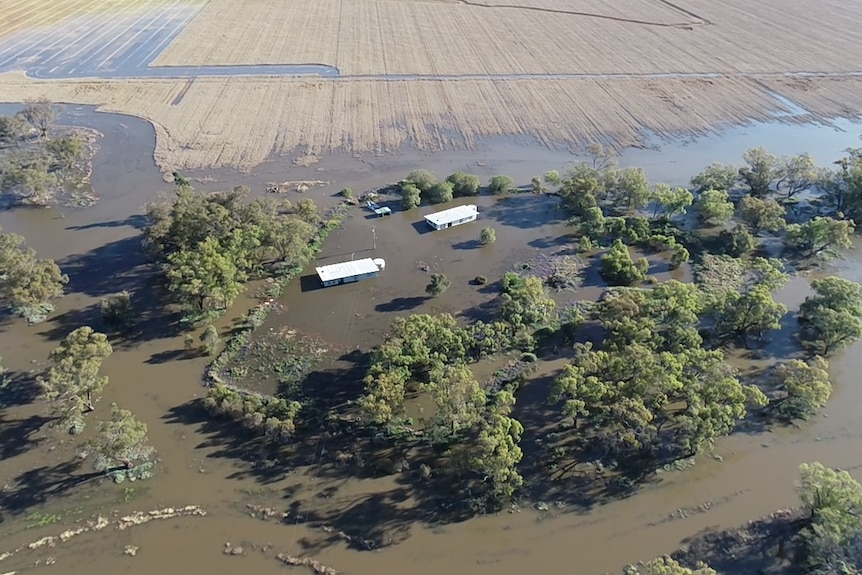 Aerial view of two houses surrounded by flood waters 