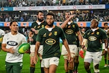 A group of South African rugby players walk off the pitch looking non-plussed after winning but failing to clinch a title..