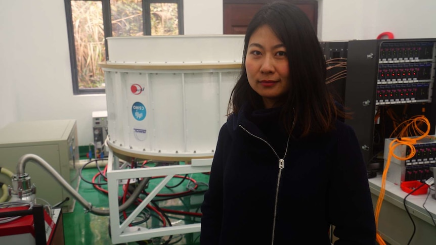 Electronics engineer Fan Jin stands in front of the CSIRO-made receiver for FAST