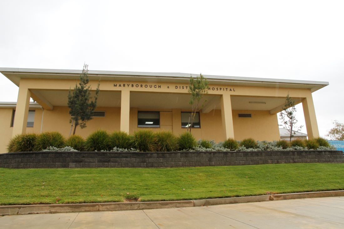 A yellow, one-storey building with Maryborough and District Hospital written in block letters on the wall.
