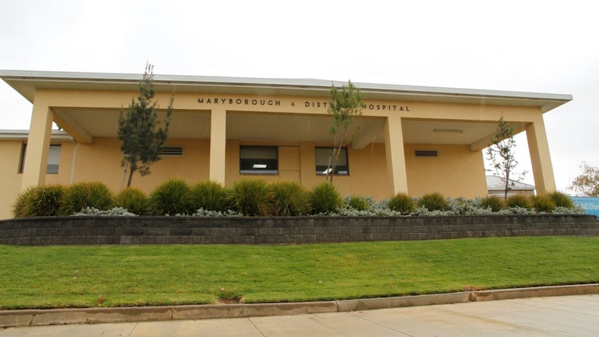 A yellow, one-storey building with Maryborough and District Hospital written in block letters on the wall.