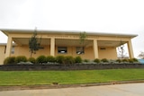 A yellow, one-storey building with Maryborough and District Hospital written in block letters on the wall.