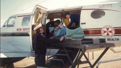 A nurse treats a patient in a plane