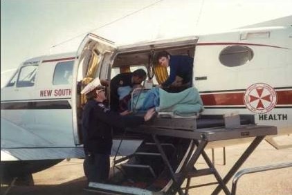 A nurse treats a patient in a plane
