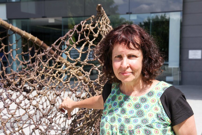 Queensland artist Judy Watson stands next to her sculpture tow row outside GOMA.