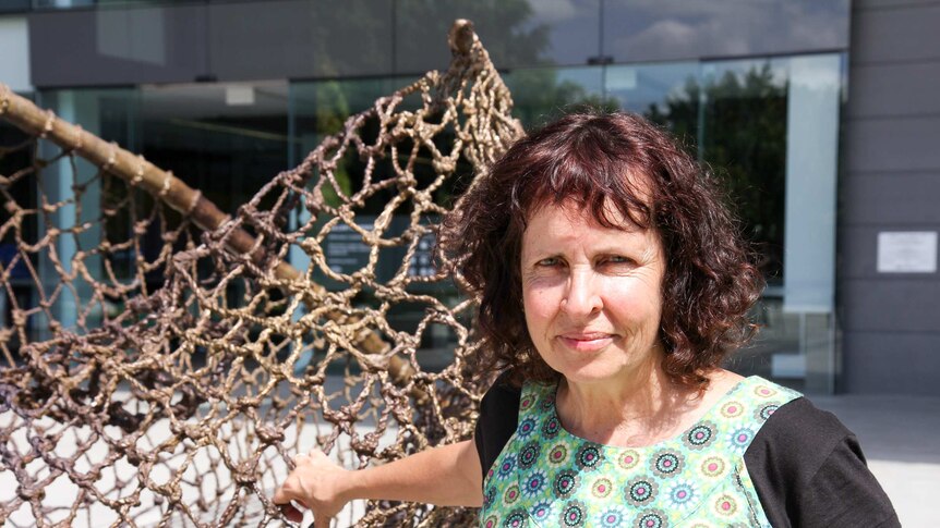 Queensland artist Judy Watson stands next to her sculpture tow row outside GOMA.