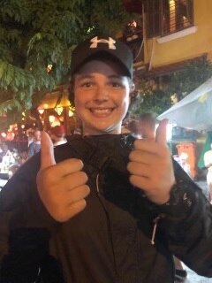 A teenage boy wearing a black hat smiling.