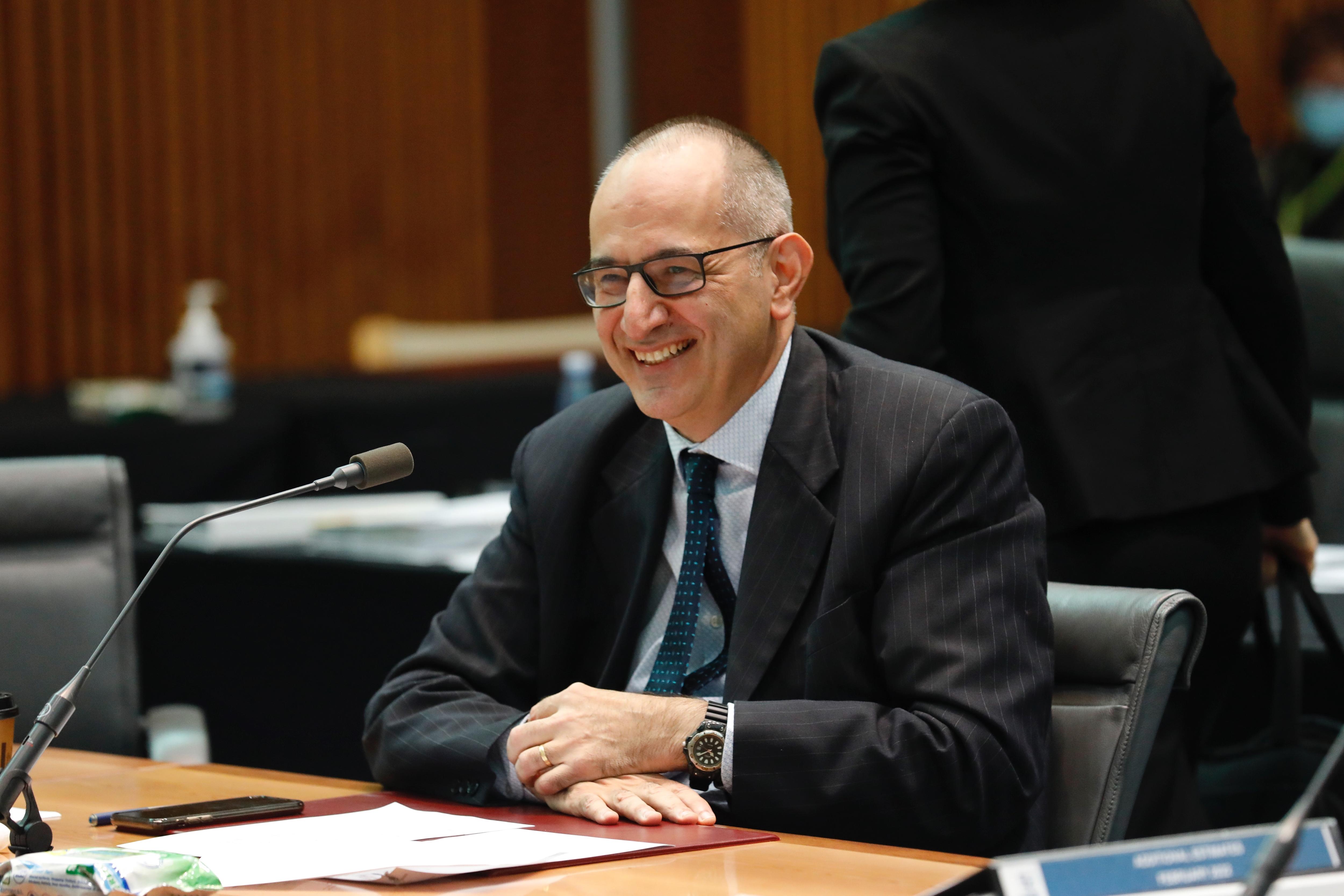 Mike Pezzullo smiles while giving evidence to a parliamentary inquiry 