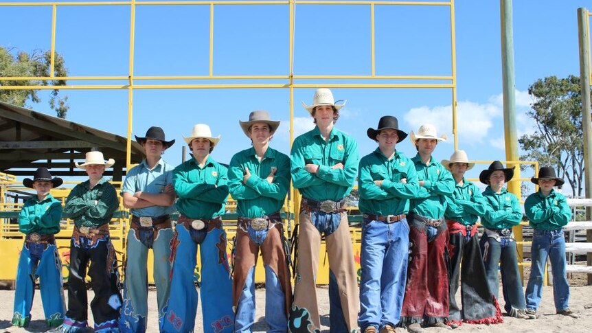 11 high school boys standing shoulder to shoulder wearing rodeo gear