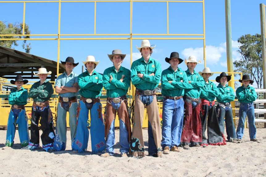 11 high school boys standing shoulder to shoulder wearing rodeo gear