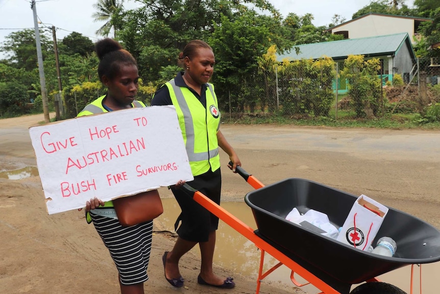 Volunteers from Red Cross Vanuatu push wheelbarrows to raise funds for Australian bushfire victims.