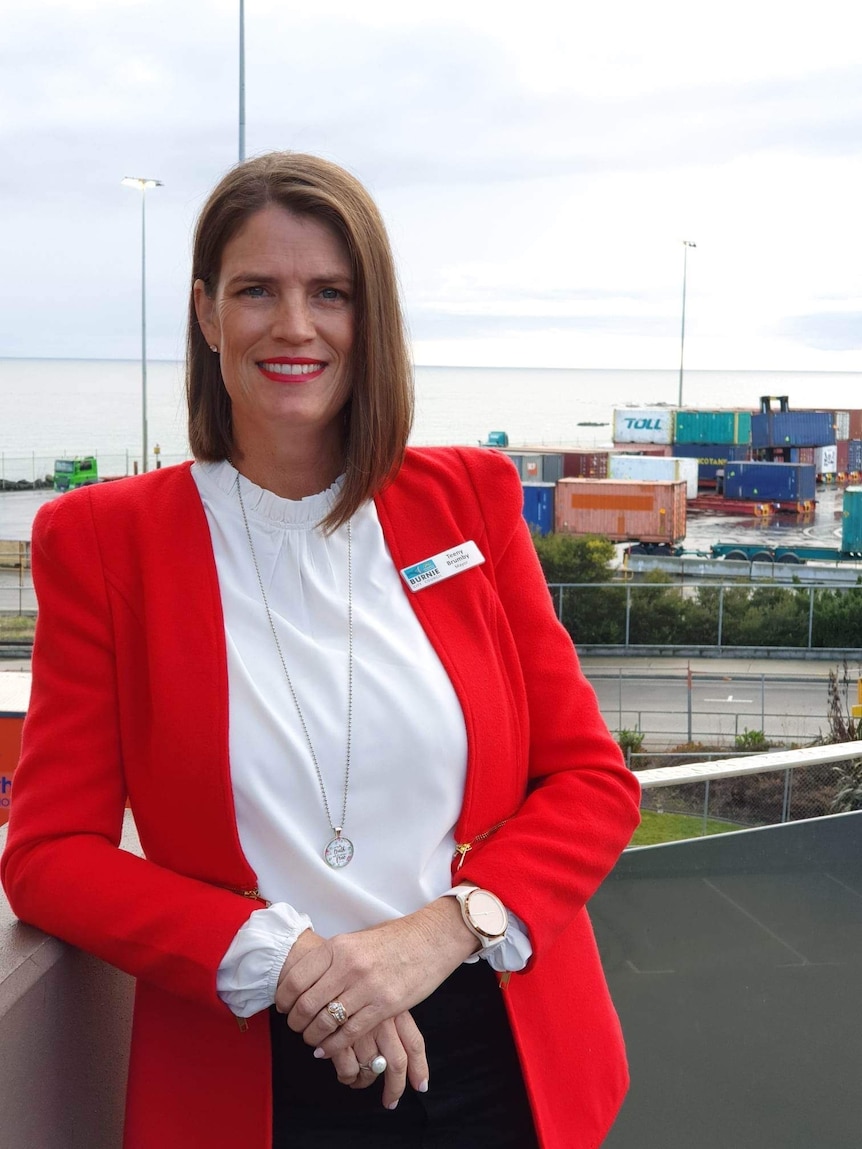 Woman with dark bobbed hear wearing a red business jacket and white shirt