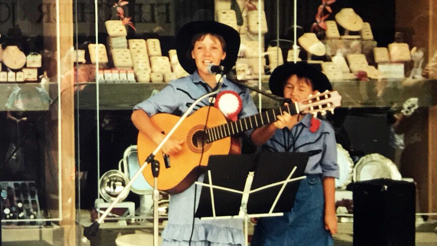 An old photograph shows Felicity Urquhart busking from a young age in front of a jewellery store in Tamworth.