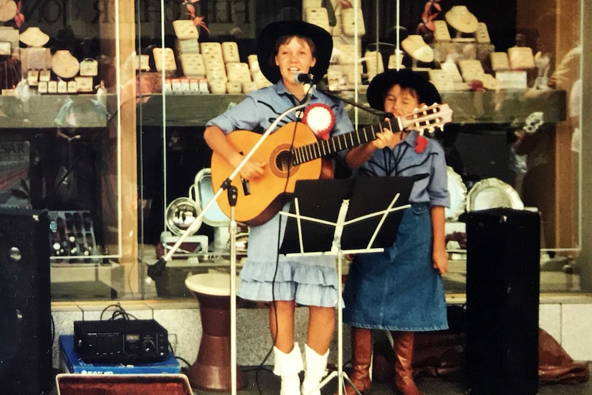 An old photograph shows Felicity Urquhart busking from a young age in front of a jewellery store in Tamworth.