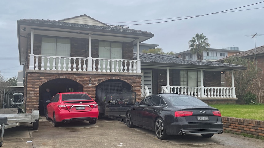 Two cars in front of a two storey house