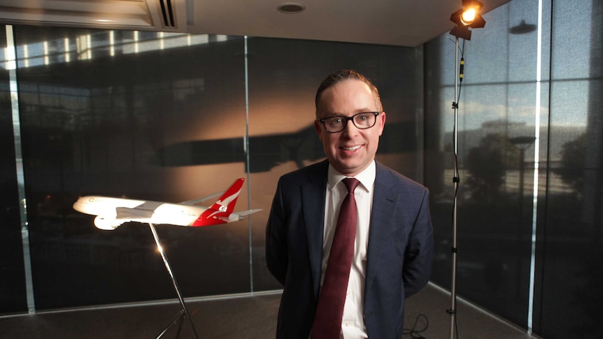 Alan Joyce stands in front of a model plane