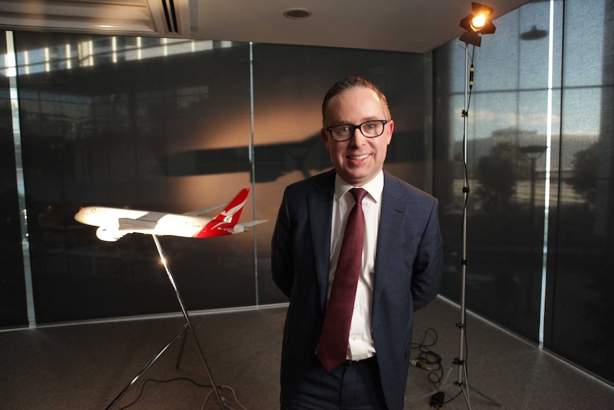 Alan Joyce stands in front of a model plane