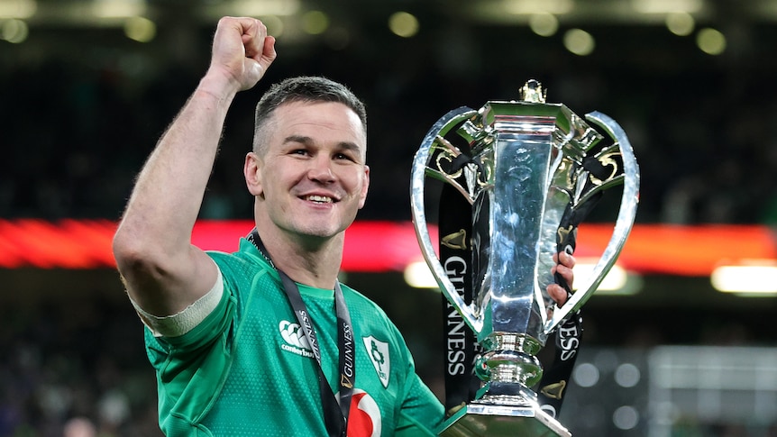 Johnny Sexton holds the Six Nations Trophy and clenches his fist