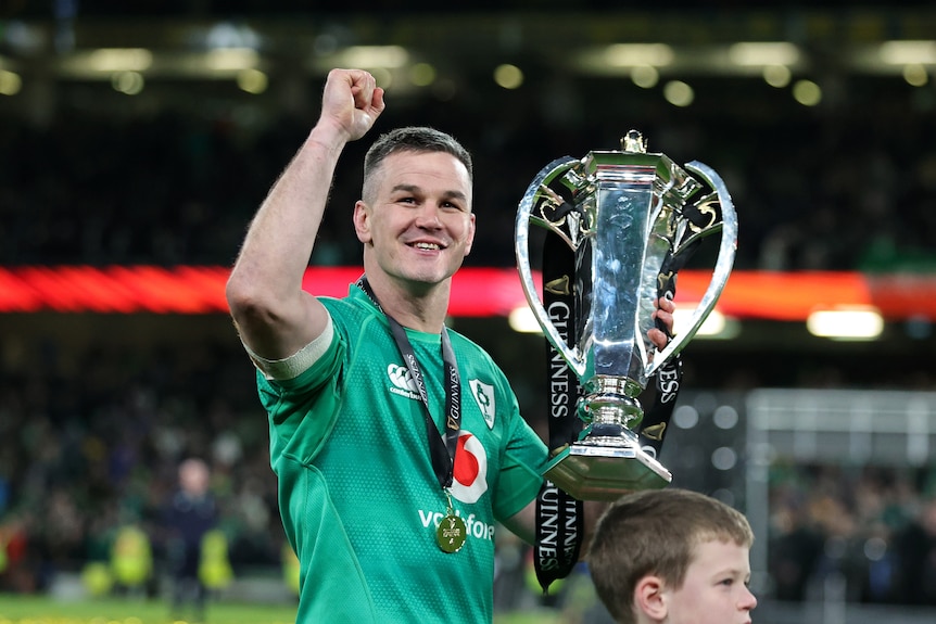 Johnny Sexton holds the Six Nations Trophy and clenches his fist
