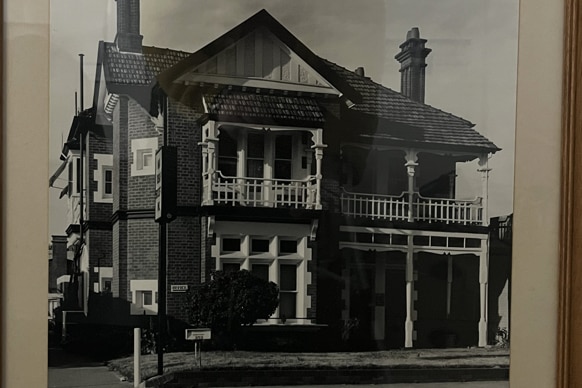 A black and white photo of an old Victorian style house 