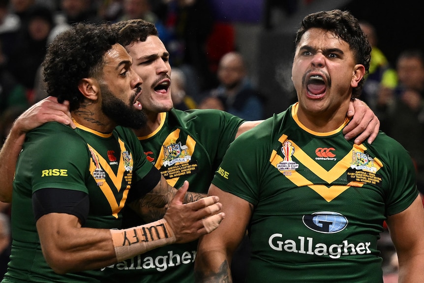 A man screams in triumphant victory and is congratulated by two team mates