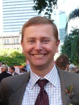 a redhead man in a suit smiling 