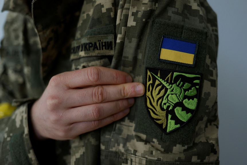 A yellow and green unicorn insignia patch on the arm of a soldier's uniform. 