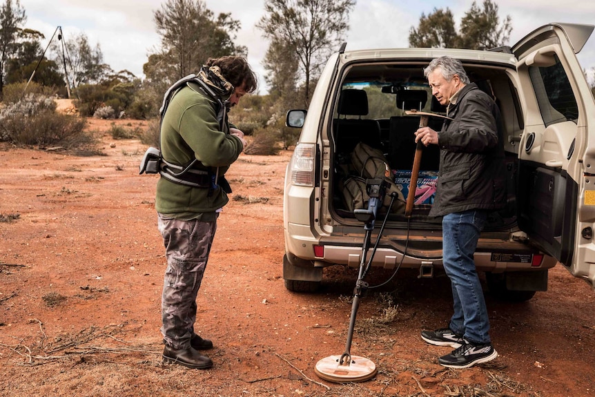 A father and son getting ready to go prospecting for gold with a metal detector.