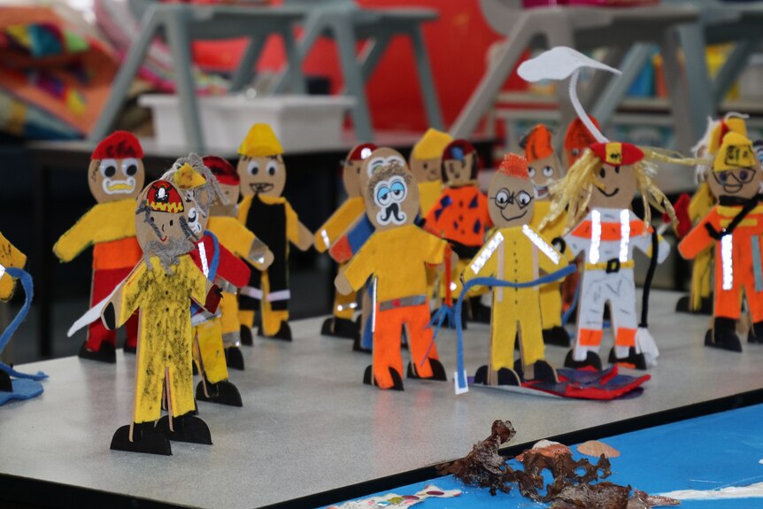 Small figurines of emergency services workers made by children grouped together on a desk.