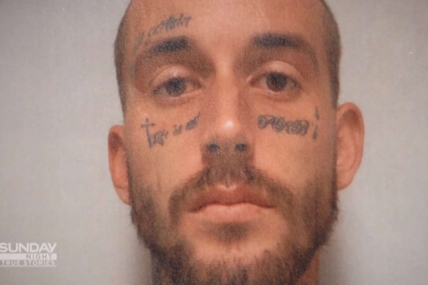 A man with his face heavily tattooed
