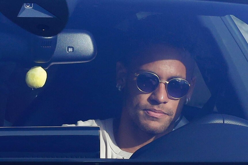 Neymar drives into the Barcelona training ground with sunglasses on.