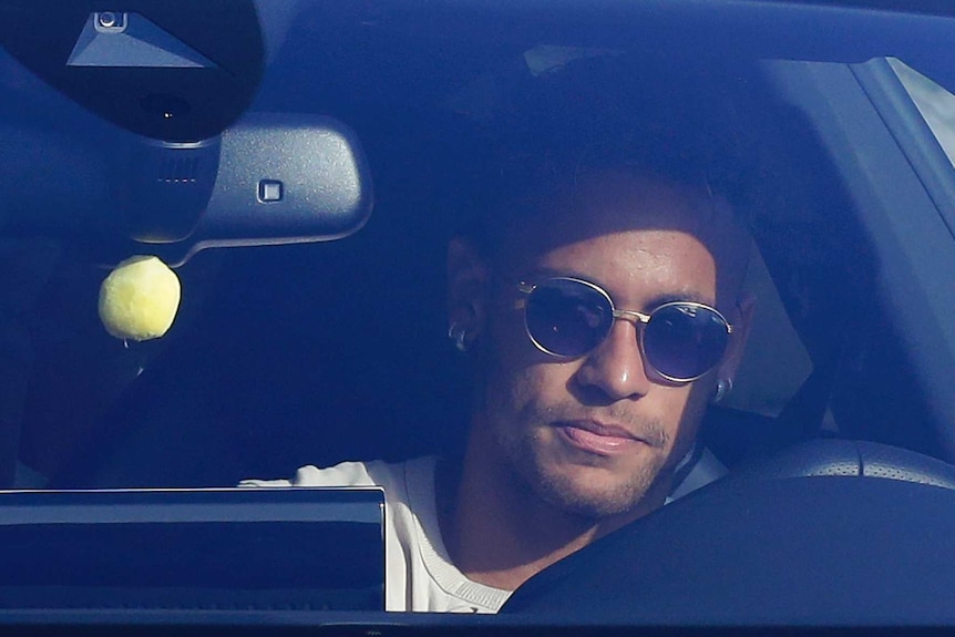Neymar drives into the Barcelona training ground with sunglasses on.