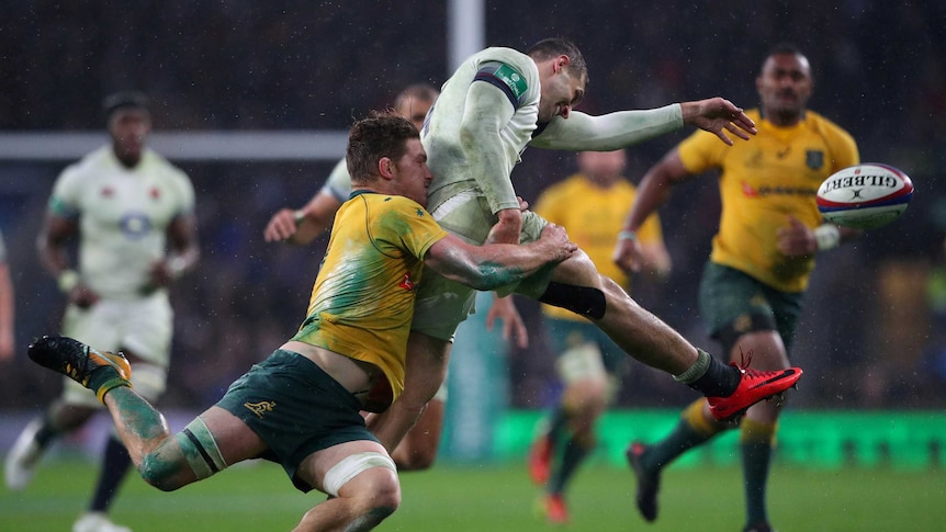 England's Jonny May kicks a football while being tackled by the Wallabies' Michael Hooper