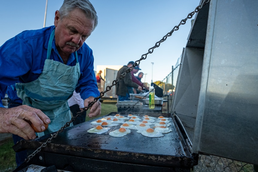 A local man cooks eggs on a barbeque for breakfast