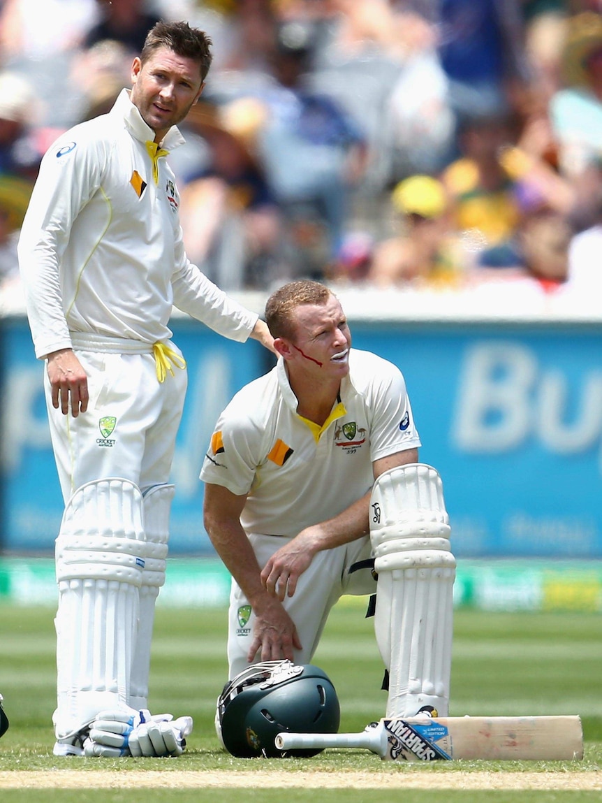 Michael Clarke checks on Chris Rogers after he was struck in the head by a delivery from Stuart Broad.