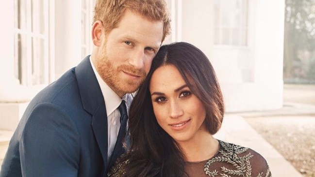 Prince Harry and Meghan Markle sit together, holding hands, with Ms Markle's engagement ring visible on her hand.