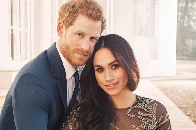 Prince Harry and Meghan Markle sit together, holding hands, with Ms Markle's engagement ring visible on her hand.