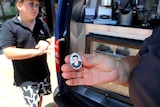A locket photo is being held up in front of a coffee van.