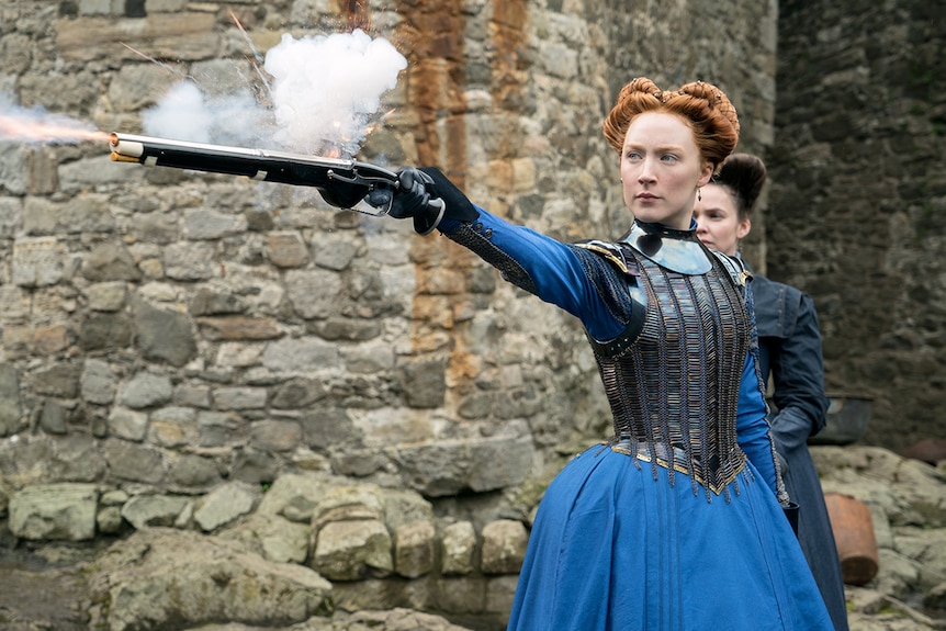 Colour still of Saoirse Ronan shooting a firearm as Mary Stuart in 2018 film Mary Queen of Scots.