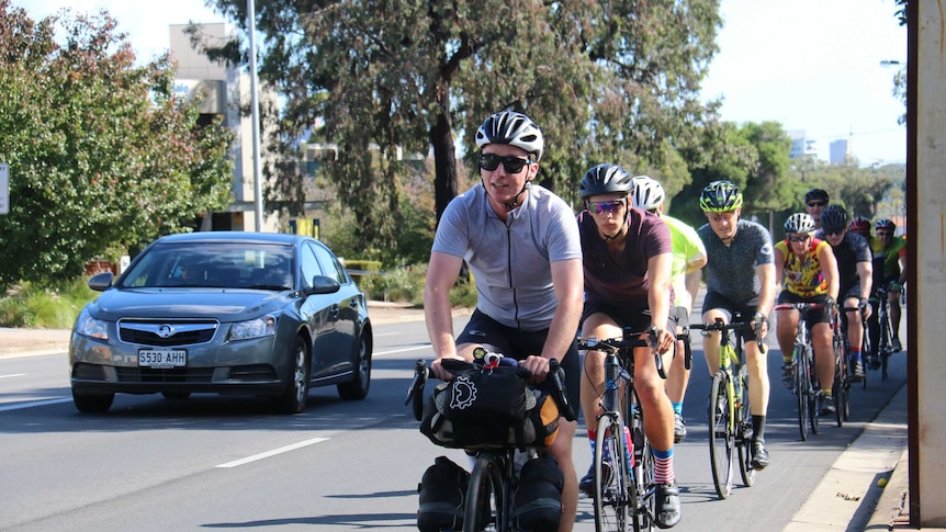 Jimmy Ashby on the road with a group of cyclists as he begins his ride around the world.