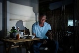 A man on his balcony waiting for the phone to call