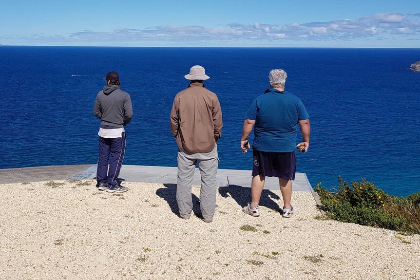 Three men backs to camera.