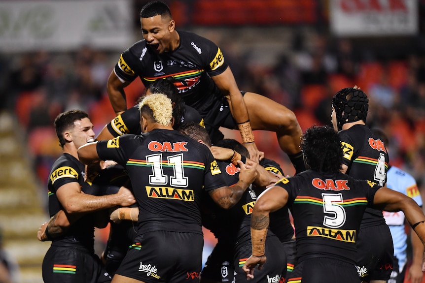 A number of Panthers players converge in a big celebratory group hug