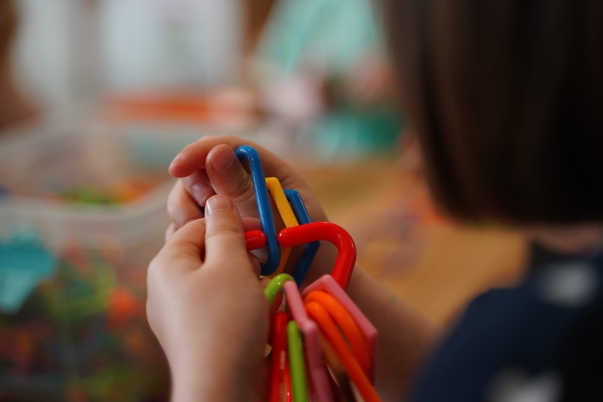 Busy hands play with a toy at a day care centre.