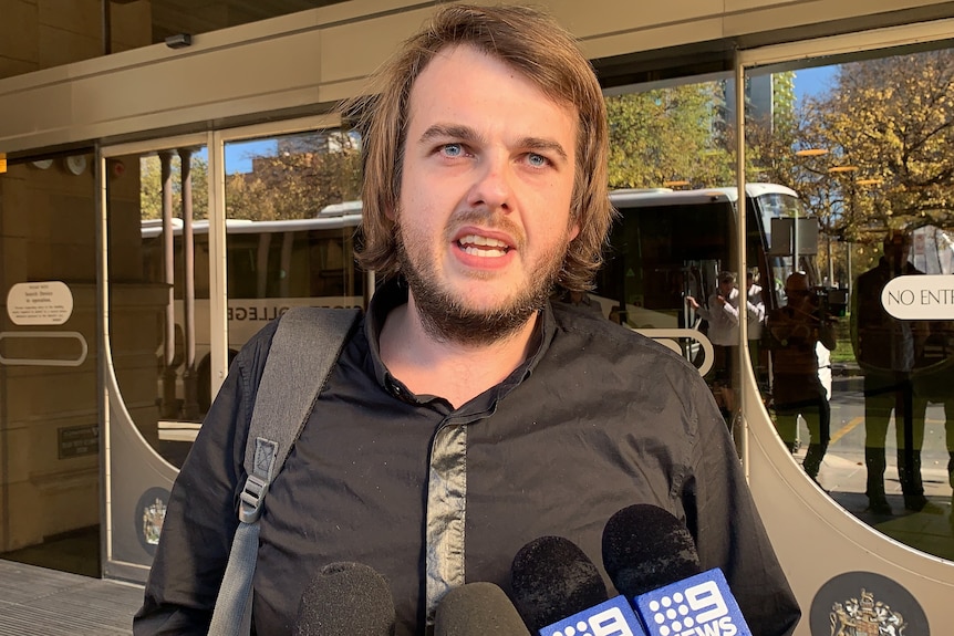 A man with a beard outside a court