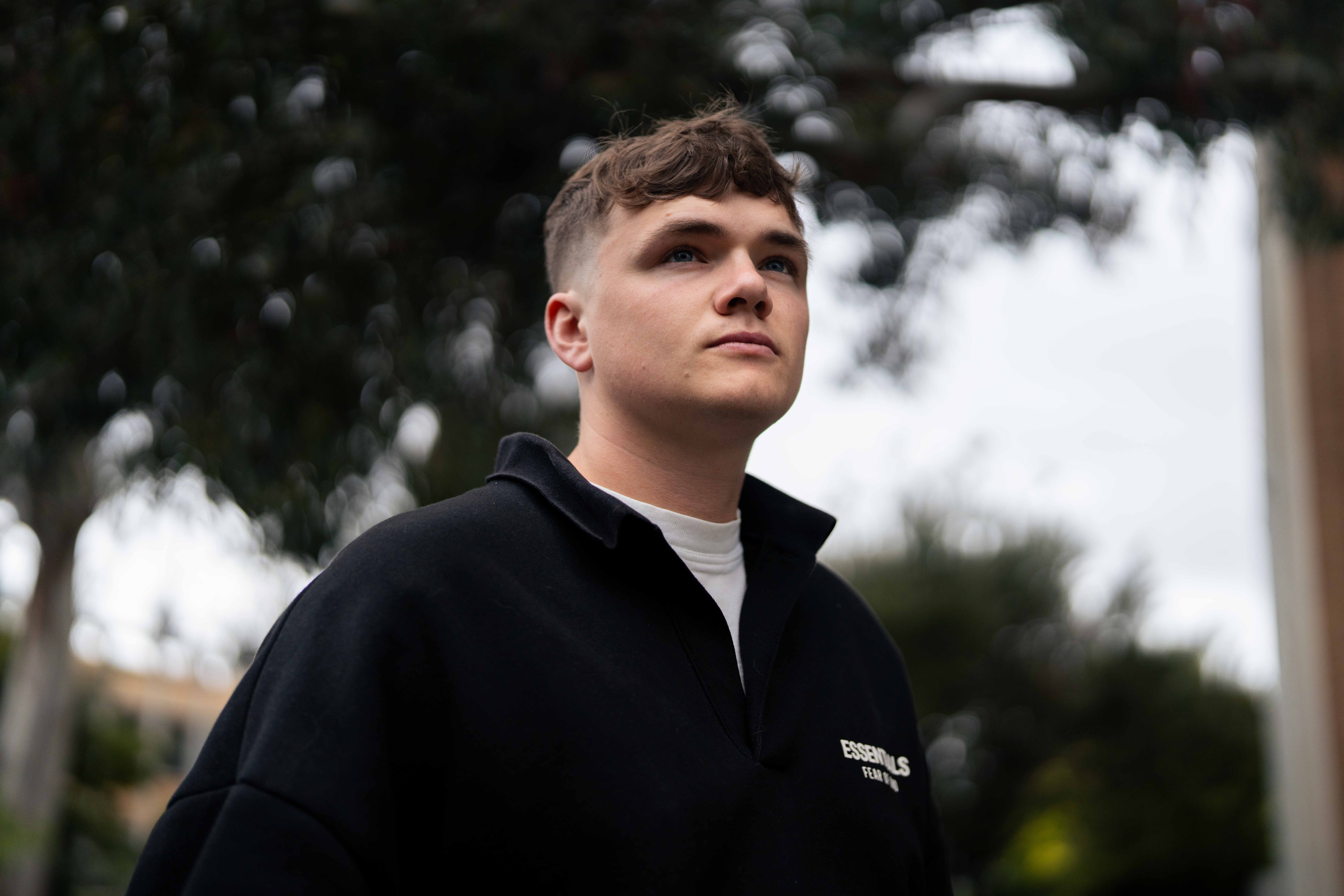 Man stands looking out to a university campus