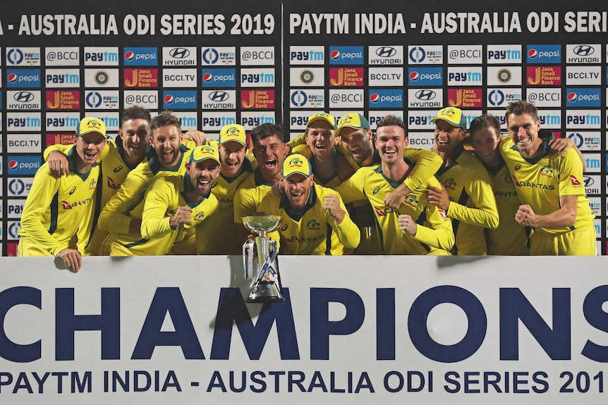 Australian cricketers gather in a huddle to celebrate winning the series against India